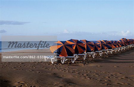 Sun loungers and umbrellas lined up on the beach at Playa Matagorda in the early morning