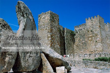 Tourists sit in front of the imposing towers of the mediaeval castle. Francisco Pizarro,the conqueror of Peru,was born here.