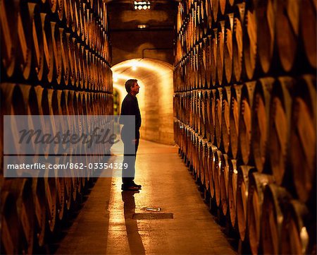 Le contremaître des travaux inspecte les tonneaux de vin de la Rioja dans les caves souterraines à Muga winery