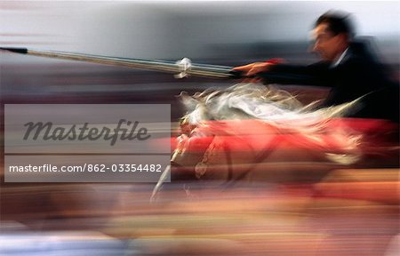 A rider on horseback speeds through the crowd attempting to strike a target with a lance. The event held in Ciutadella on the Balearic Island of Menorca is part of the festival of Sant Joan (Saint John) that celebrates the island's cavallers (horsemen).