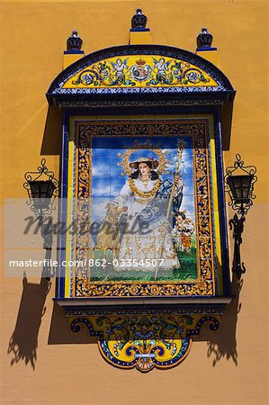 A picture made of painted ceramic tiles depicting a haloed shepherdess with child and sheep,Seville,Spain