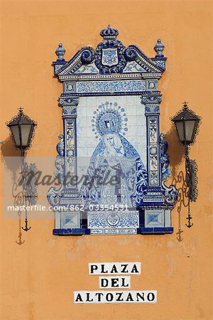 Spain,Andalucia,Seville. An elegant ceramic sign with wrought iron lanterns on a street corner in Plaza del Altozano.