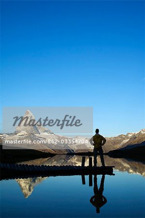 Le Cervin (4477m). Reflet de la montagne dans un petit lac, le randonneur contemple la beauté du paysage, Zermatt, Valais, Suisse