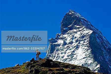 The Matterhorn (4477m). Hiker on rrail below the Matterhorn's peak The Matterhorn (4477m). Hiker on rrail below the Matterhorn's peak
