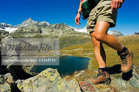 Hiker on trail above lake at Schwarzee Paradise,Zermatt,Valais,Switzerland