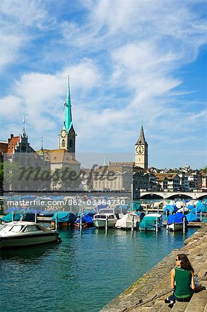 Boats on the Limmat River with St Peter's Church (13th Century) and Fraumunster Church behind,Zurich,Switzerland