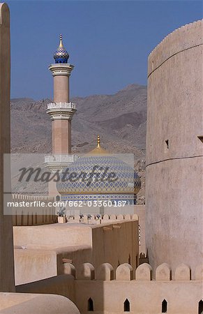 Die blaue und goldene Kuppel und Minarett der Moschee Sultan Qaboos umrahmt werden von den Türmen der Nizwa Fort.