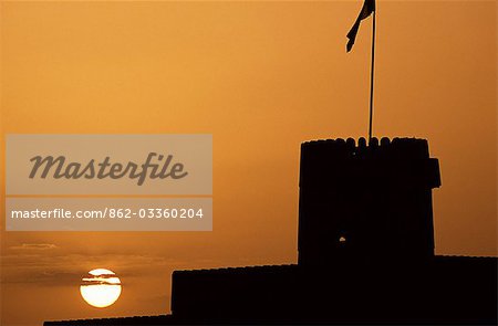 Silhouette of one of the towers of Ras al Hadd Castle at sunset. The 450 year old castle stands looking out to sea. It has 3 towers and a courtyard large enough to take all of the villagers when they were threatened with invasion. An escape tunnel travels 200m outside the fort into what was then a dwelling.