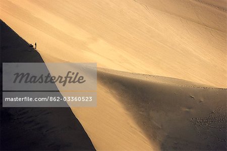 Hikers are dwarfed by a giant sand dune above the desert oasis of Huacachina,near Ica in southern Peru Hikers are dwarfed by a giant sand dune above the desert oasis of Huacachina,near Ica in southern Peru