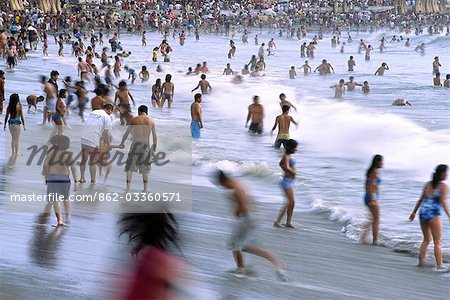 The summer crowds flock to the beach at Huanchaco,near Trujillo in northern Peru. The town is famous for its fishermen that use traditional reed boats to ride the surf.