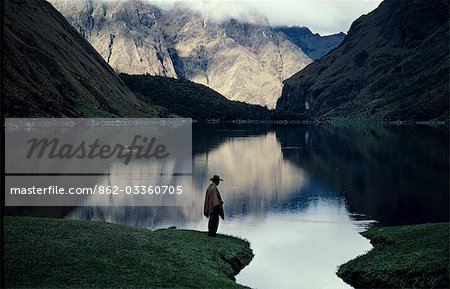 A high lake in the Vilcabamba range; at the waters edge a mule wrangler checks his fishing line at dawn. A high lake in the Vilcabamba range; at the waters edge a mule wrangler checks his fishing line at dawn.