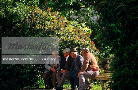 Portugal, Alentejo, Portalegre. Vieillards en passant de l'heure sur un banc de parc.