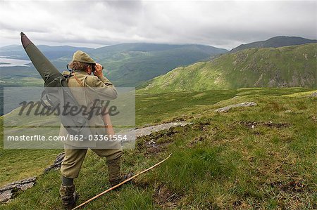 Stalker Benmore Estate, Neilson Bissett, sur la colline de traque de red deer. Il porte des jumelles, télescope, fusil de chasse et bâton de marche.