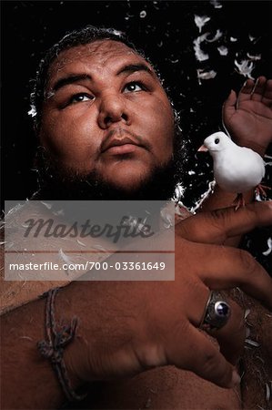 Man Covered in Feathers, Holding Birds in His Hands