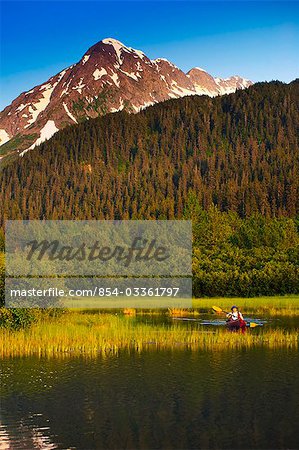 Man in a kayak paddling in a lake in Portage Valley, Southcentral, Alaska, Summer