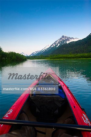 Point de vue tout en pagayant dans un lac dans la vallée de Portage au coucher du soleil, centre-sud de l'Alaska, l'été de kayakiste