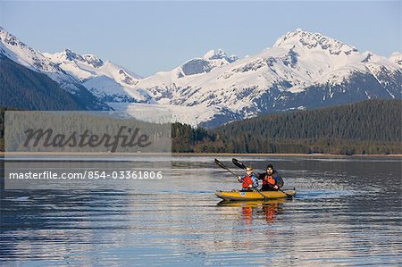 Kayakistes pagaient sur les eaux calmes du Passage de l'intérieur de l'Alaska avec Herbert Glacier en arrière-plan, la forêt nationale de Tongass près de Eagle Beach State Recreation Area.