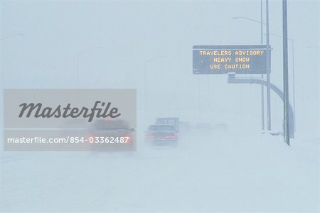 Voitures sur l'autoroute en avis de tempête de neige signent Anchorage AK/nSouthcentral hiver