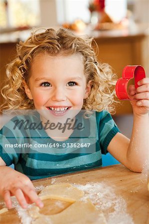 young girl cutting cookies