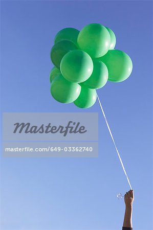 Hand mit grünen Luftballons