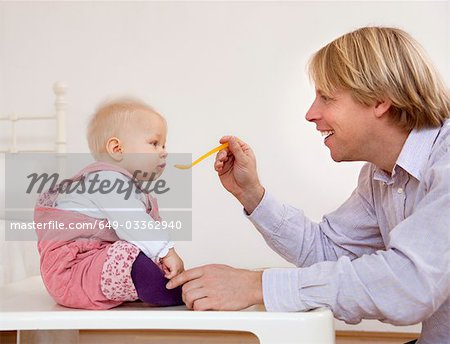 father feeding baby