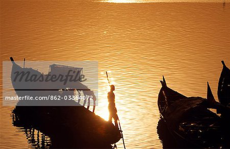 Passenger boats pushing off into Niger River at sunset