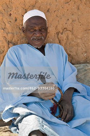 Mali,Dogon Country. An old man,prayer beads in hand,rests near the mosque at Songho.