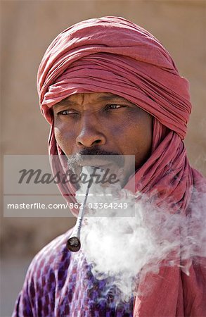 Mali,Timbuktu. A Tuareg man smokes a traditional metal pipe in Timbuktu.