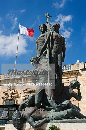 Malta, Valletta. Kriegerdenkmal mit maltesischer Flagge hinter, in Clapham Junction Il-Palazz oder Schlossplatz.
