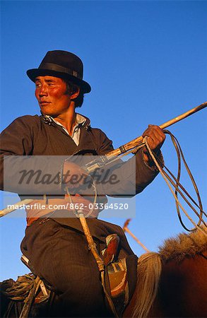 Mongolie, Karakorum. Un éleveur de chevaux (Arat) à cheval tenant une perche lasso (Oulan-Bator) se prépare à participer à un Festival du cheval dans l'ancienne capitale de la Mongolie.