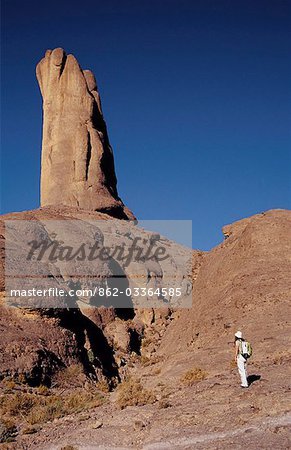 A trekker admires the impressive free-standing rock tower at Bab n'Ali. These volcanic formations in the Jbel Sahro range attracts trekkers from all over the world.