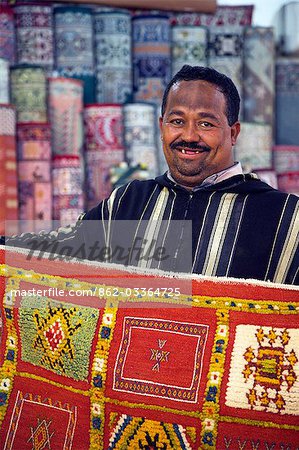 A carpet salesman displays his wares in the souq of Marrakesh