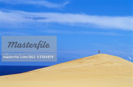 Un touriste se dresse au sommet d'une dune de sable sur l'île de Benguerra face à l'océan Indien