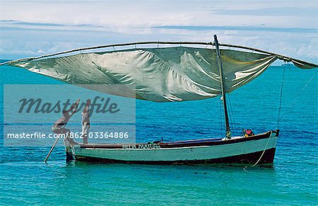 Fishermen pole their dhow out from the beach to deeper water