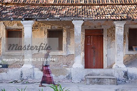 A woman in front of an old Portuguese villa on Ibo Island,part of the Quirimbas Archipelago,Mozambique.
