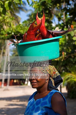 Mozambique,Inhaca Island. A local African lady carries her catch of fish on her head,in Inhaca village on Inhaca Island. Inhaca Island is the largest island in the Gulf of Maputo,and lies 24km from the mainland.