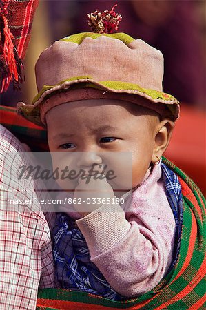 Myanmar,Burma,Lake Inle. A Pa-O child carried on her mother’s back at Indein market.