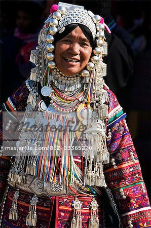 Myanmar,Burma,Kengtung. An Akha woman wearing traditional costume with a silver headdress and necklace embellished with glass beads.