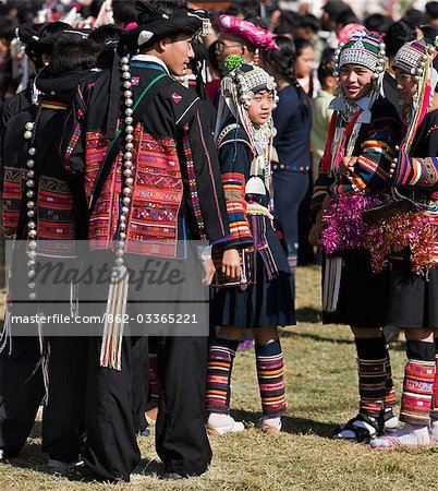 Myanmar,Burma,Kengtung. A gathering of Akha men and women wearing traditional costumes at an Akha festival.