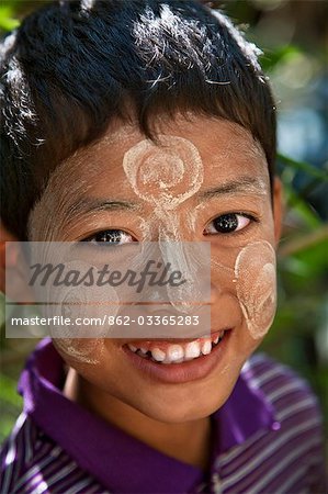 Myanmar, en Birmanie, la rivière Kaladan. Un garçon de l'ethnie Rakhine décore son visage avec Thanakha, une crème solaire locale populaire.