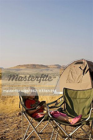 Région de Namibie, Damaraland, Etosha. Une jeune fille se repose sous une présidence bush sur safari.