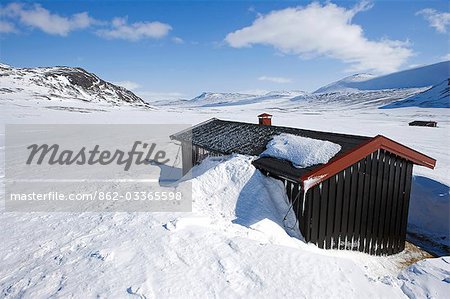 Troms, Norwegen Lyngen Alpen. An einem Tag schönes Wetter bietet eine nützliche Wahrzeichen von navigieren, aber eine Berghütte bietet wichtige Schutz auf dem Hochplateau.