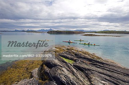 Norvège, Nordland, Helgeland. Explorer l'archipel côtier de Norvège, une équipe de kayakistes de mer font leur chemin thorugh un chapelet d'îles.