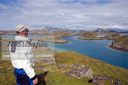 Norvège, Nordland, Helgeland. Kayak de mer enquêtes sur son parcours à travers les canaux complexes créés par le grand nombre de petites îles des côtes de Norvège