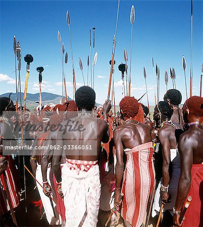 Samburu warriors sing in a circle during a wedding celebration. As they sing and dance,they twist their spears in unison. Soloists ad-lib words to traditional tunes,praising the bravery of certain individuals or the bulls of their families' herds.