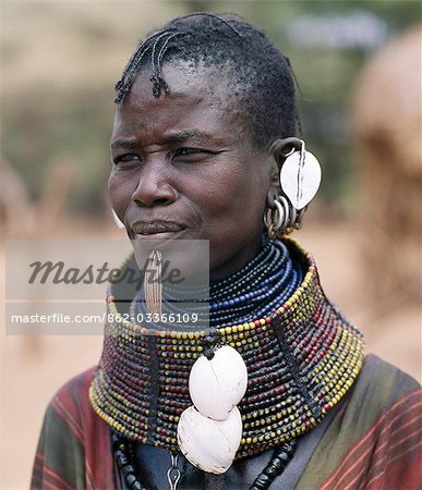 Une femme de Turkana porte tous les atours de sa tribu : Branchez la lèvre en laiton, perles collier orné de coquilles blanchies de l'Escargot africain, ornements d'oreille foliacée et boucles d'oreilles métalliques d'où pendent des petits anneaux de corne de chèvre.