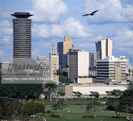 The Nairobi city skyline with Kenya's Parliament buildings in the foreground. A Black Kite (Milvus migrans) flies overhead.