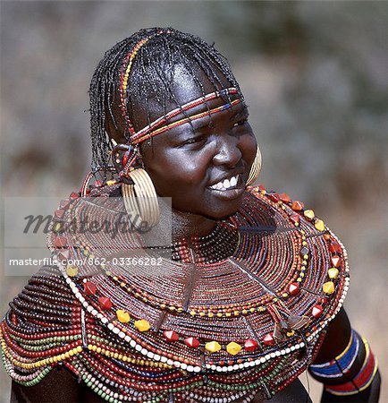 A young married woman of the Pokot tribe. Her married status is denoted by her large brass earrings and broad beaded collars and necklaces that are smeared with animal fat to glisten in the sun.