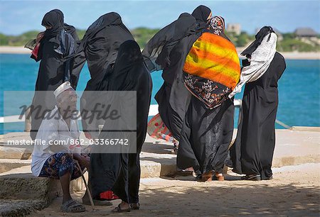 Insel Lamu, Kenia Shela. Eine Gruppe von muslimischen Frauen und ein alter Mann warten auf eine Fähre in Shela Pier.