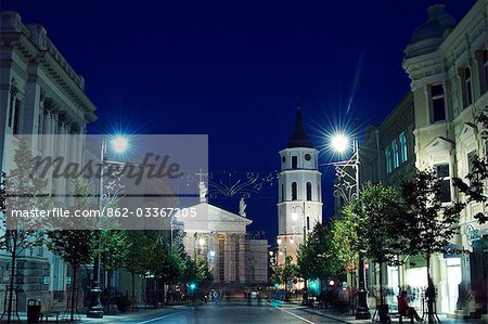 Lithuania,Vilnius. Shopping district on Gedimino Street at night and Vilnius cathedral bell tower 13th Century - part of Vilnius Unesco World Heritage Site.